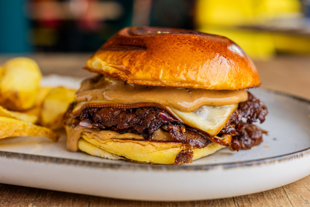A close-up of a juicy vegan burger with melted vegan cheese — vegan burgers Las Vegas