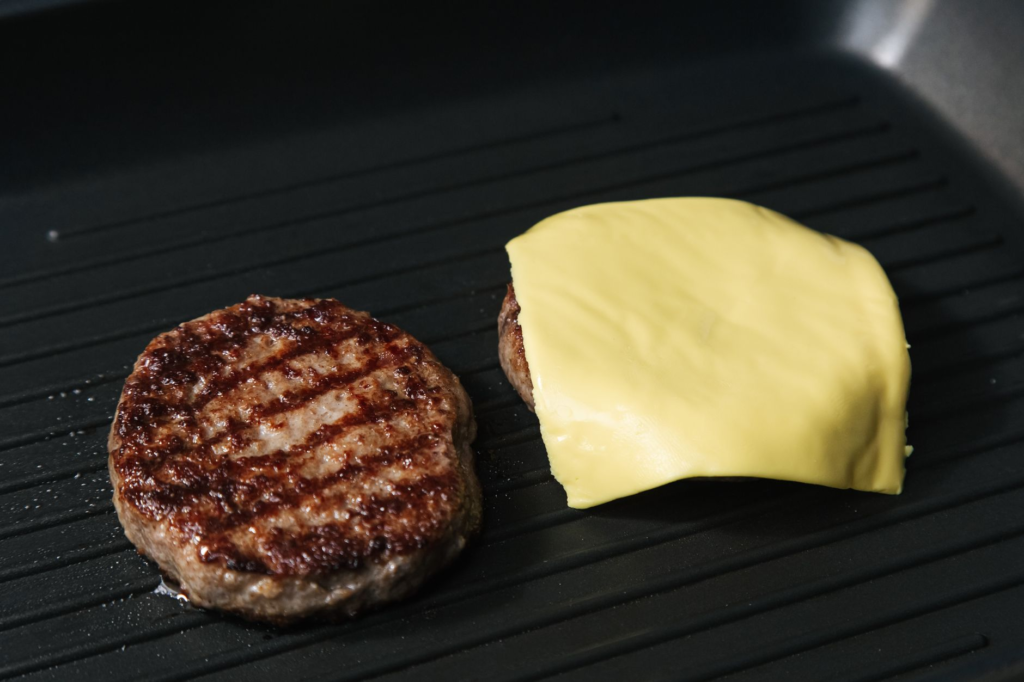 A close-up of a perfectly grilled smash burger with melted cheese — smash burger vs regular burger