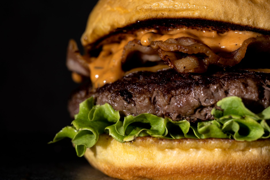 A close-up of a secret burger, highlighting its juicy patty and fresh ingredients. — hidden gem burgers Las Vegas