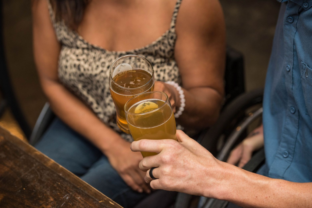 A couple toasting with craft beers in a burger restaurant. — romantic restaurants las vegas