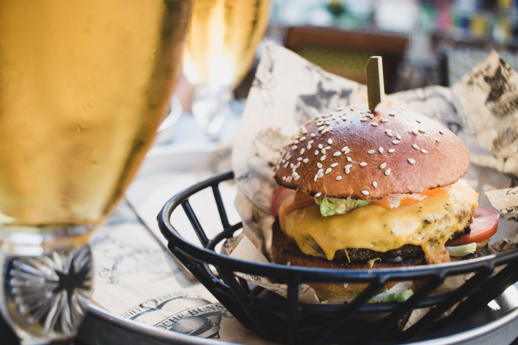A delicious gourmet burger topped with fresh ingredients and a pint of craft beer beside it. — burger beer pairings Las …