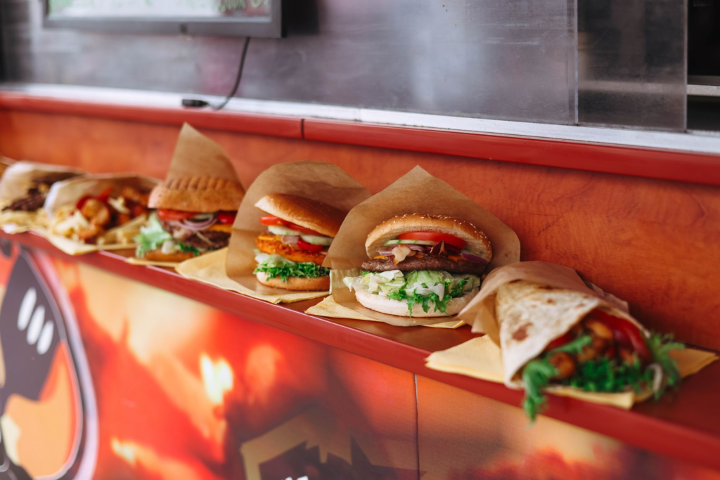 A diverse selection of burgers from various restaurants displayed in a food festival. — las vegas burger faq