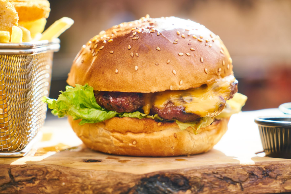 A mouth-watering cheeseburger with melted cheese and fresh toppings on a wooden table. — best burgers in Las Vegas