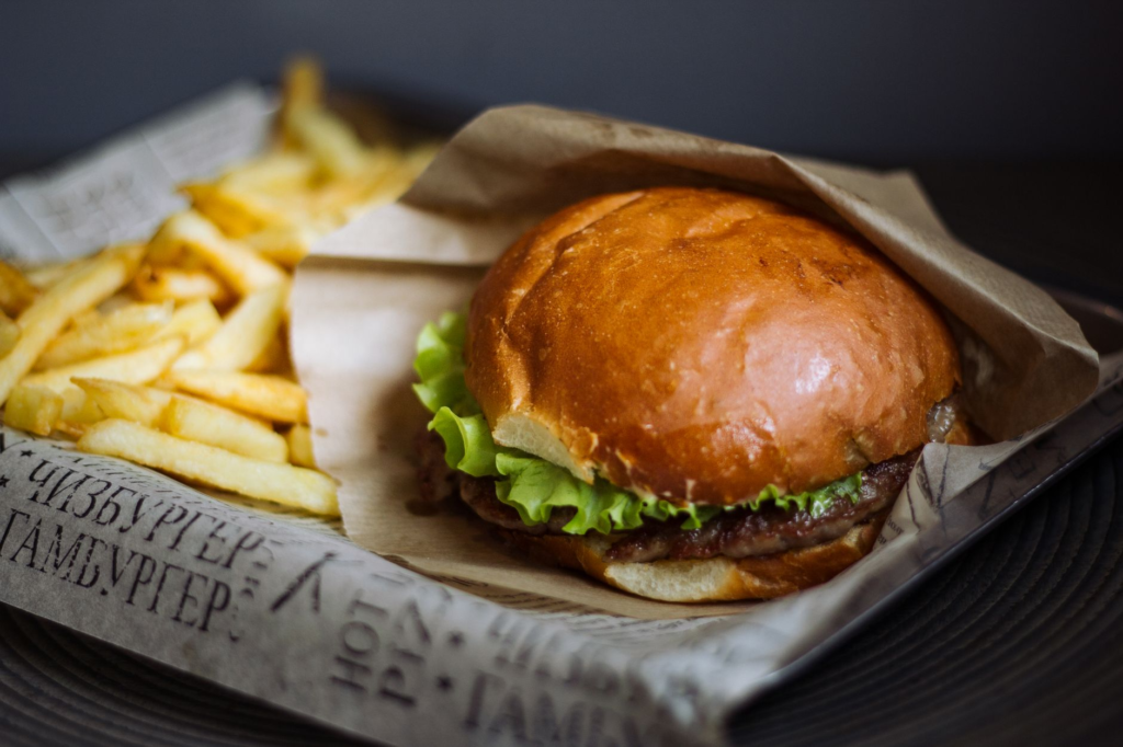 A mouth-watering close-up of a juicy burger with fries on the side, showcasing the deliciousness of burger deals in Las Ve…