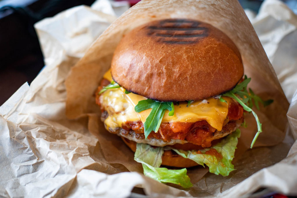 A mouth-watering close-up of a juicy cheeseburger with melted cheese and fresh toppings. — juiciest burgers Las Vegas Strip