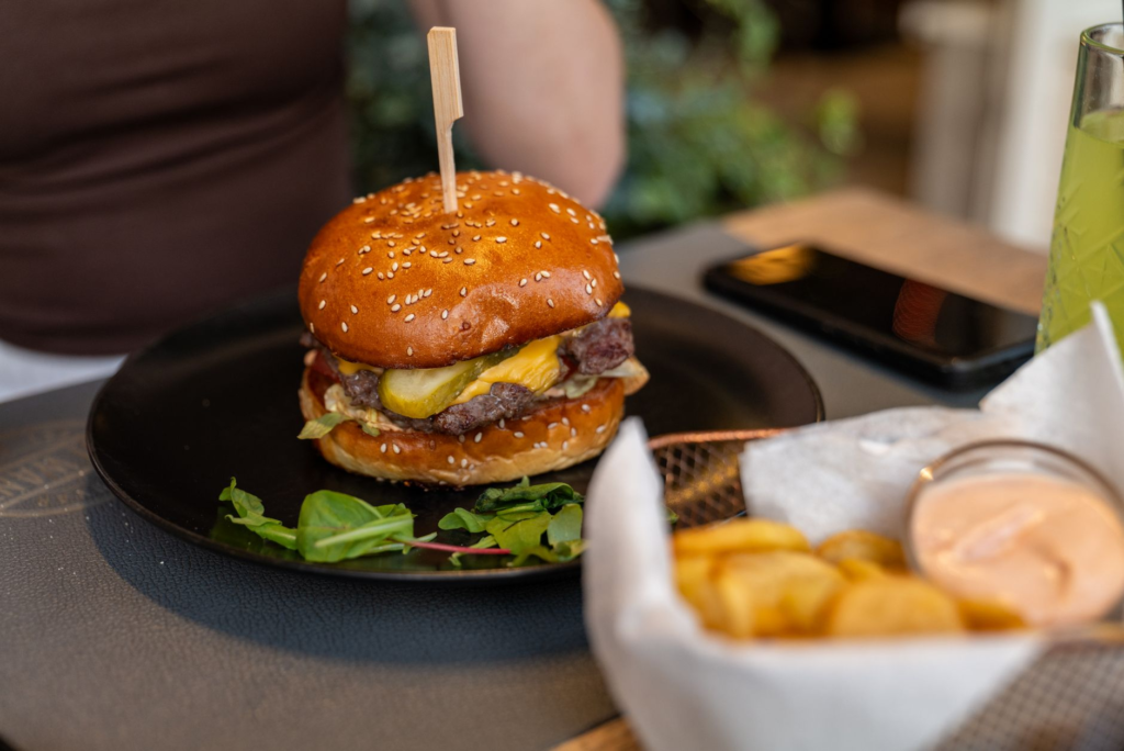 A plate of perfectly golden fries served alongside a gourmet burger in a vibrant restaurant setting. — best burgers down…