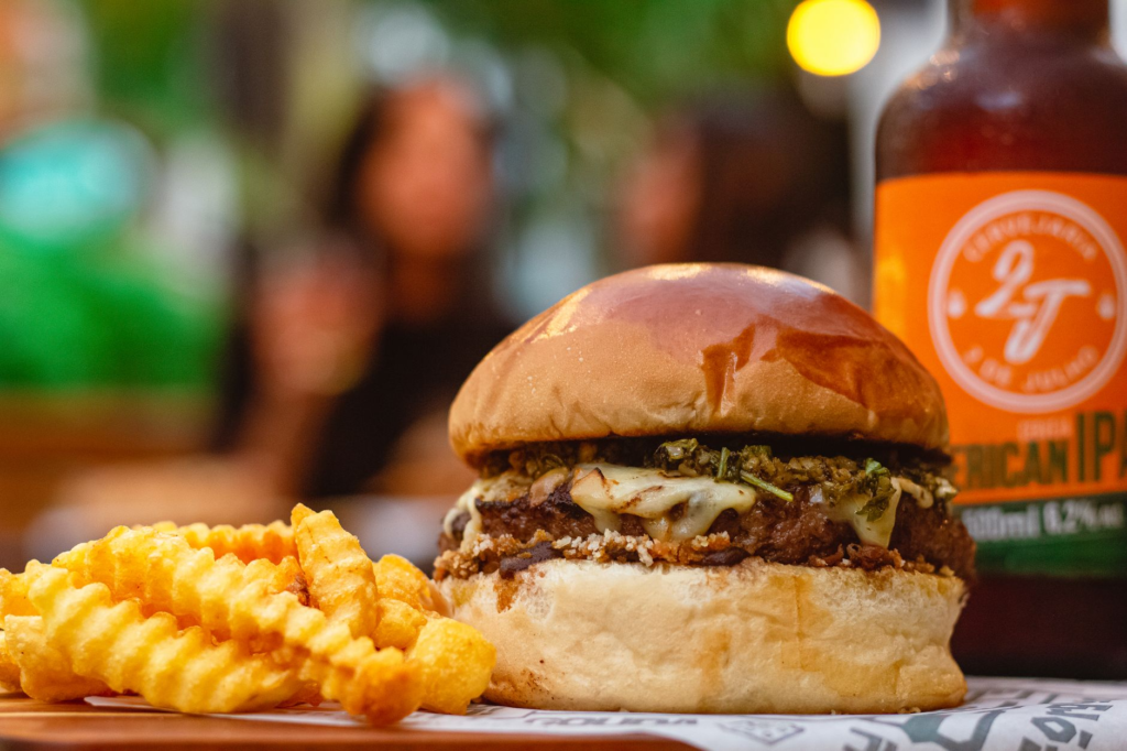 A spicy jalapeño burger with a vibrant IPA in the background. — burger beer pairings Las Vegas