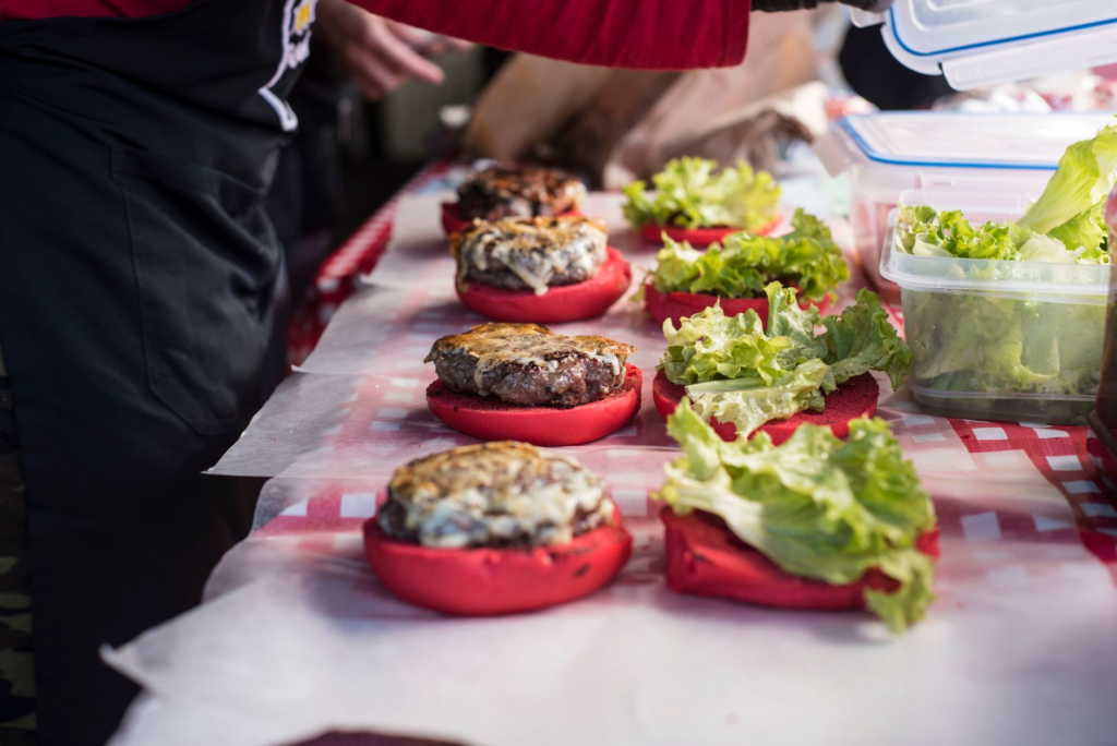 A vibrant Las Vegas food festival featuring various burger vendors showcasing Las Vegas burger chains vs locals