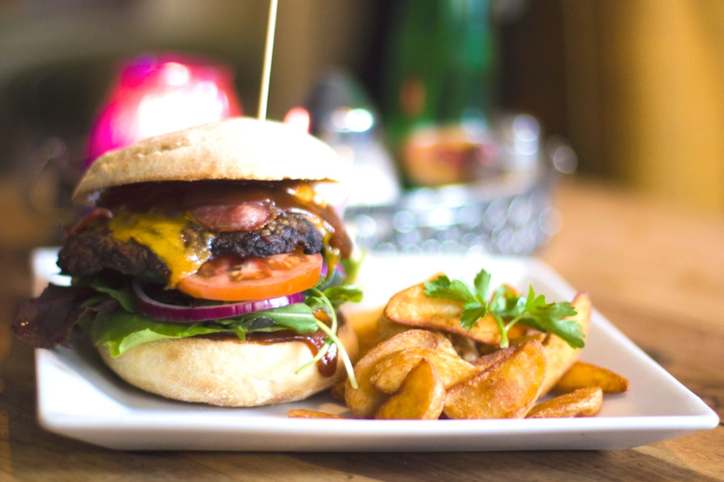 A vibrant plate of a classic vegan burger with fresh toppings and a side of sweet potato fries. — vegan burgers Las Vegas