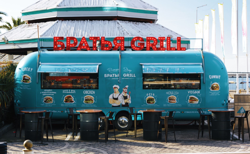 An outdoor festival setting with food stalls offering vegan burgers and snacks. — vegan burgers Las Vegas