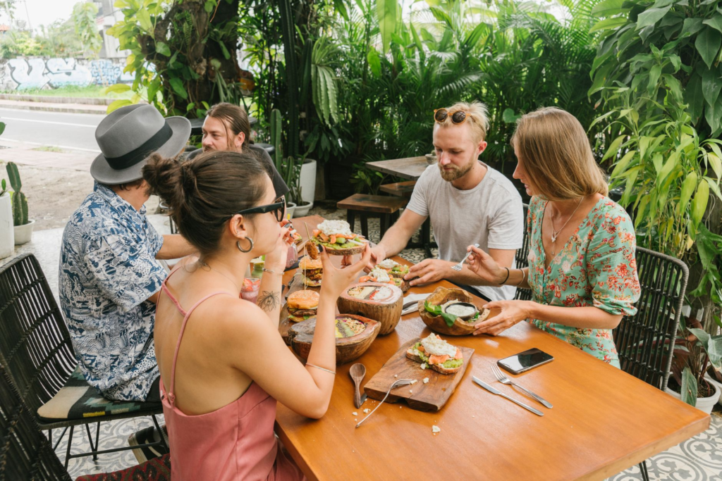 An outdoor patio setting at a vegan restaurant, featuring diners enjoying their meals under the sun. — vegan burgers Las…