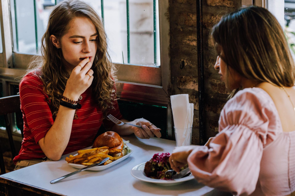 An outdoor setting featuring a group of friends enjoying Instagrammable burgers at a trendy Las Vegas eatery. — Instagra…