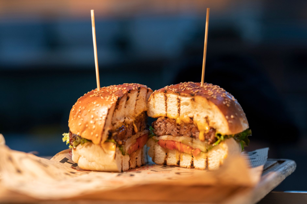 Close-up of a gourmet burger with fresh ingredients and sauces. — choosing the best burger