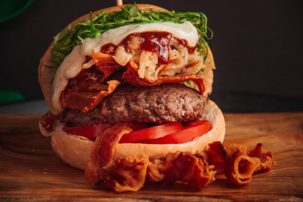 A close-up shot of a signature burger with fresh toppings. — unique burgers Las Vegas