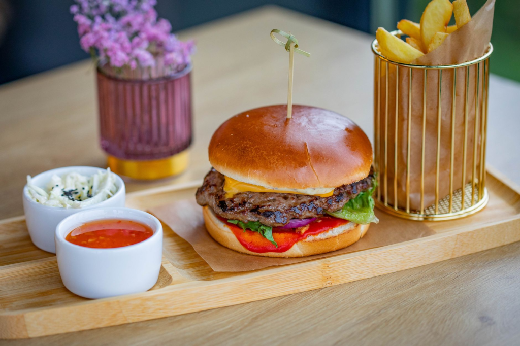 A visually appealing burger with colorful sauces and sides. — unique burgers Las Vegas